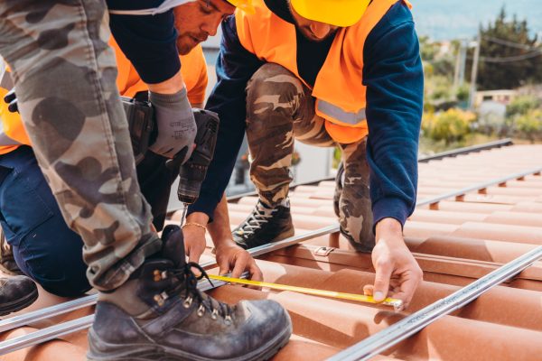 Team of technical workers work on the roof