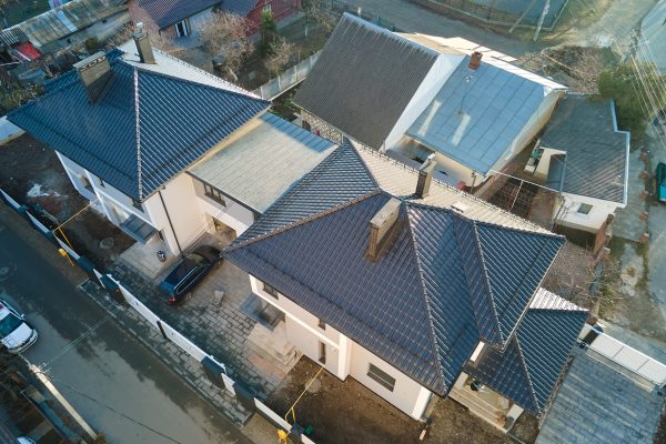Aerial view of private house with ceramic shingles covered roof top. Investment in real estate concept.